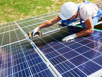 Technician working on a rooftop solar panel